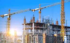 Bauarbeiten auf einer Großbaustelle mit mehreren Kränen.