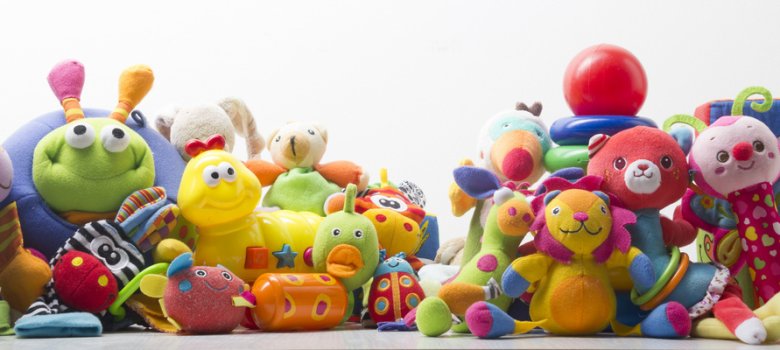 Kinderspielzeug und Kuscheltiere auf weißem Hintergrund.