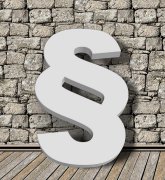 Das Symbol des Paragraphen vor einer Mauer stehend