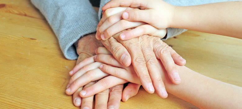 Viele Hände liegen übereinander auf dem Tisch