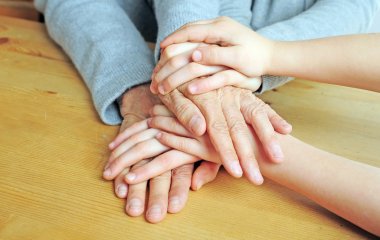 Viele Hände liegen übereinander auf dem Tisch