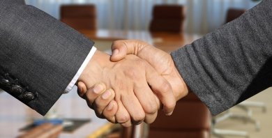 Bildausschnitt, zwei Personen schütteln sich die Hand