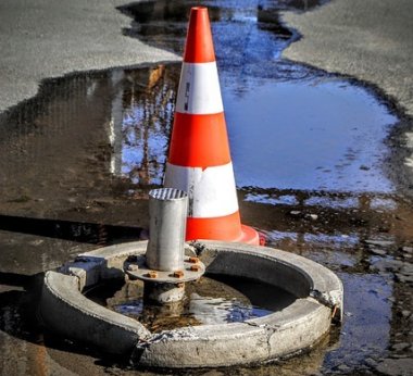 Wasserrohrbruch Straße mit Warnaufsteller