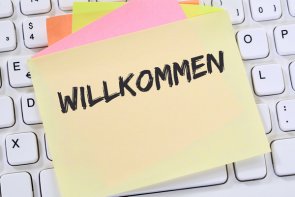 Auf einer Tastatur aufgeklebter Notizzettel mit der Aufschrift Willkommen