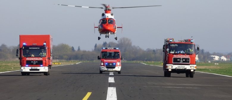 Feuerwehrautos und Rettungshubschrauber in einer Reihe