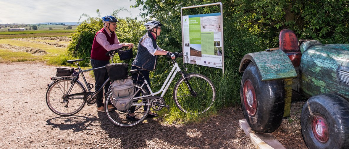 Zwei Radfahrer informieren sich an einer Infotafel