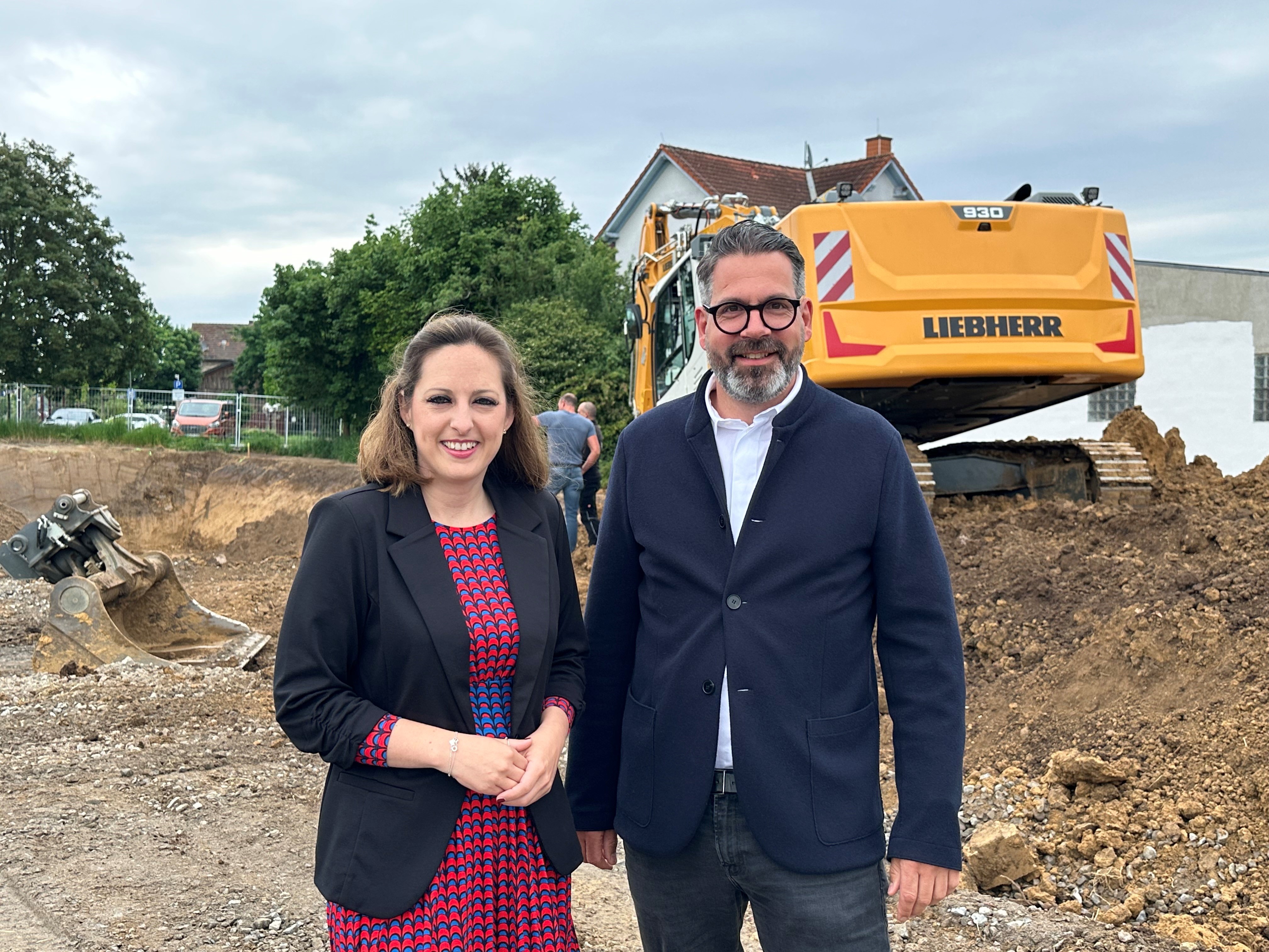 Im Vordergrund Lena Herget, Bürgermeisterin Reichelsheim und Michael Schmale, Geschäftsführer raab.schmale GmbH. Im Hintergrund die Baustelle in Reichelsheim 