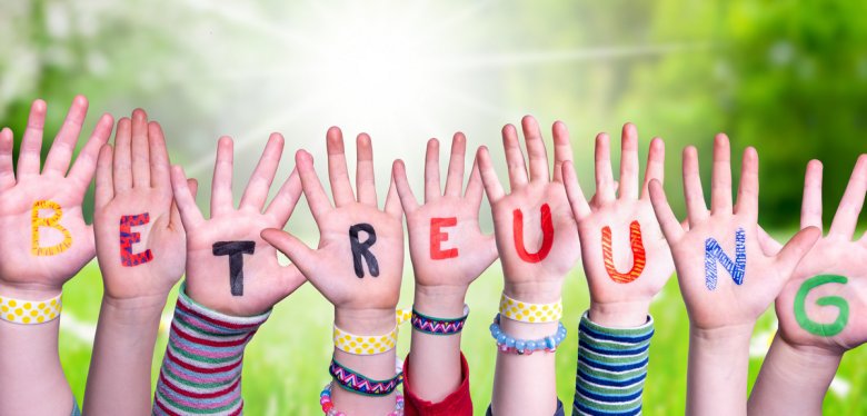 Kids Hands Holding Word Betreuung Means Day Care, Grass Meadow