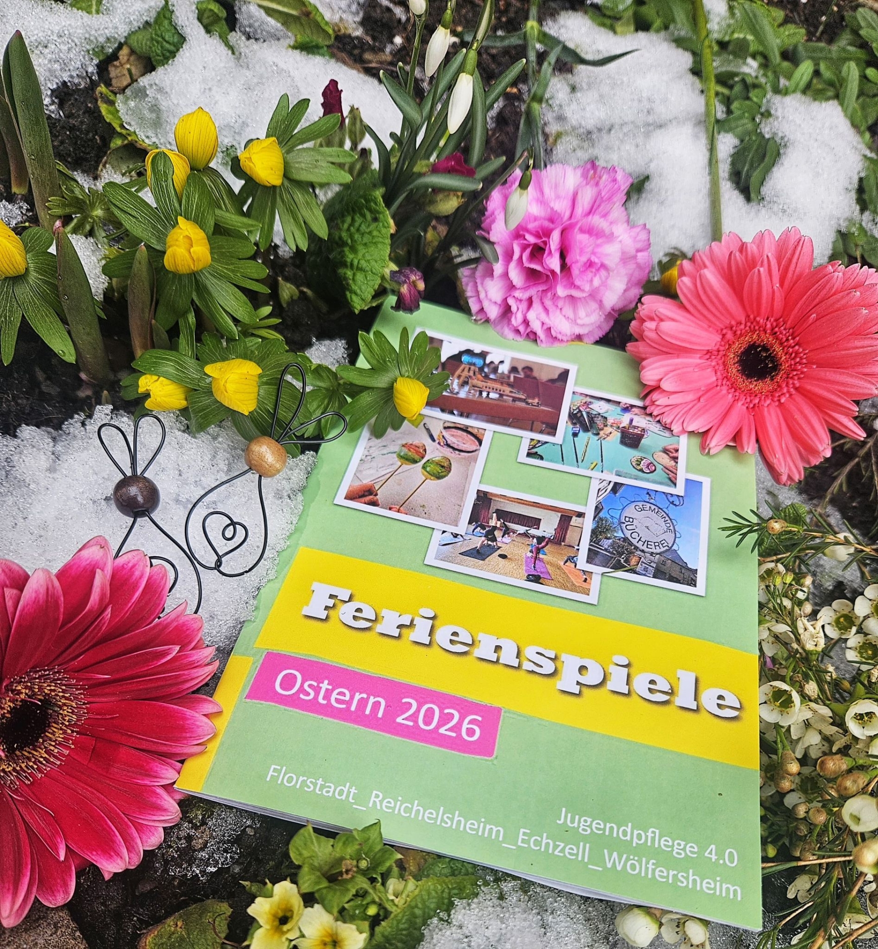 Das Ferienspielheft mit Frühlingsblumen eingerahmt