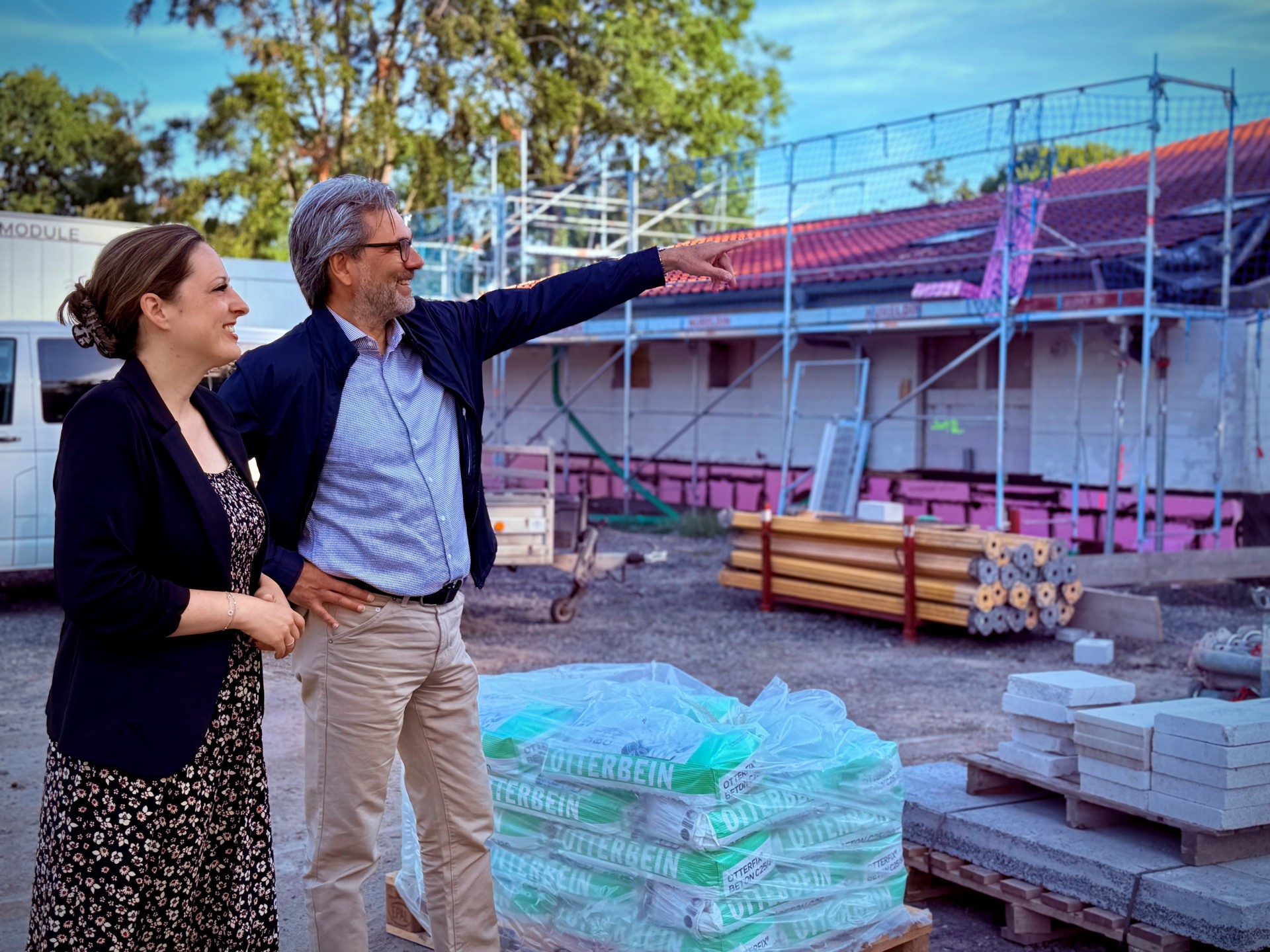 Bürgermeisterin Lena Herget und Achim Parbel, Vorstand der Mittelhessischen Energiegenossenschaft eG (MiEG) vor dem eingerüsteten Bürgerhaus Reichelsheim