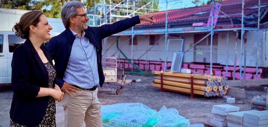 Nachhaltige Energie für das Bürgerhaus Bürgermeisterin Lena Herget und Achim Parbel, Vorstand der Mittelhessischen Energiegenossenschaft eG (MiEG) vor dem eingerüsteten Bürgerhaus Reichelsheim