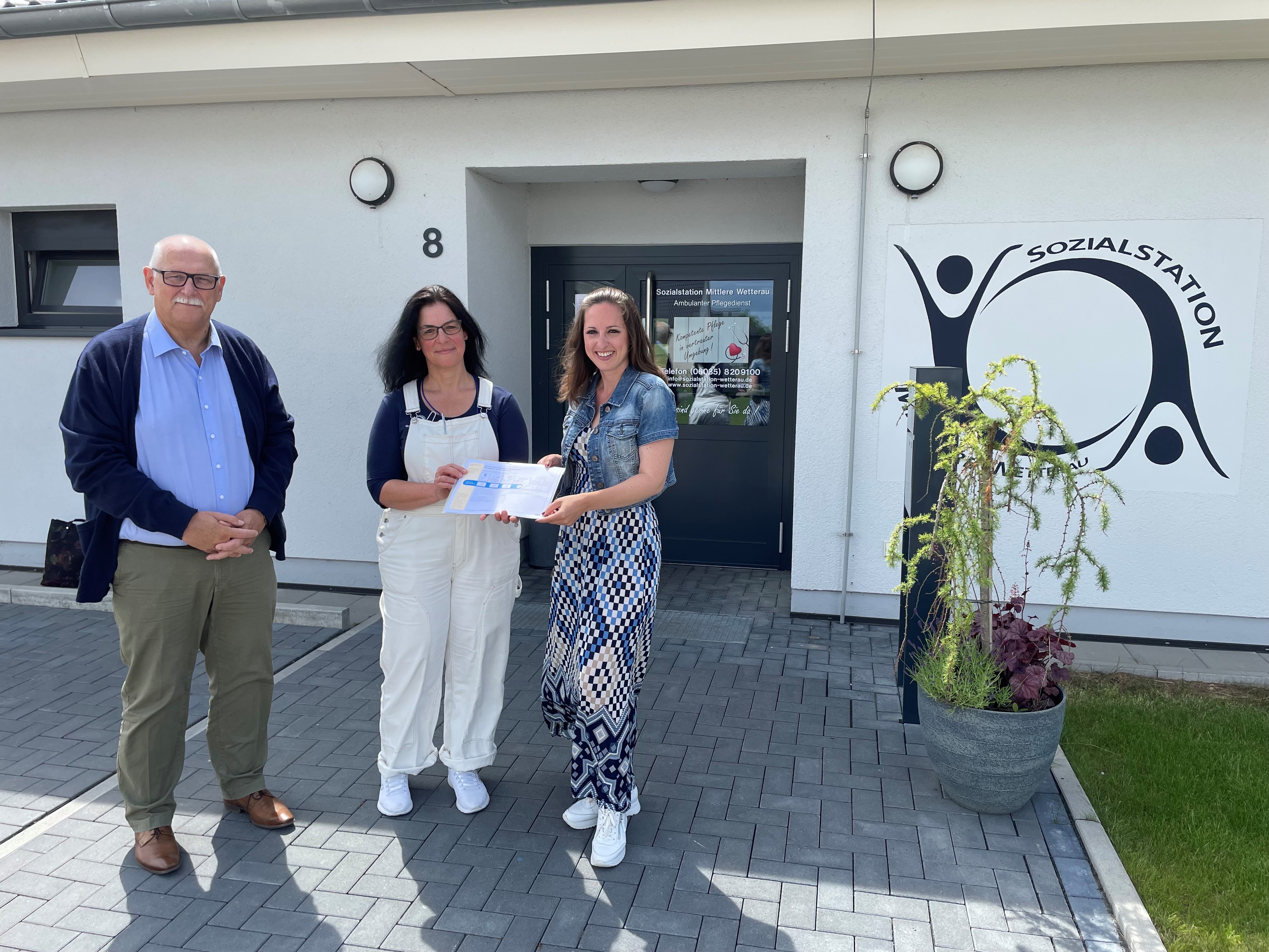 Unger, Herget-Umsonst und Brenner mit der Auszeichnung vor dem Gebäude der Sozialstation