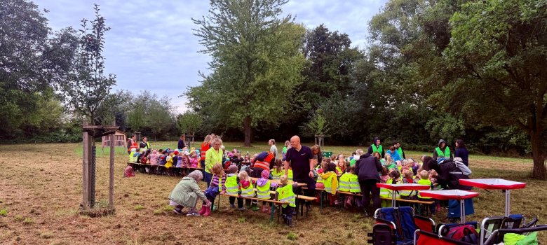 Reichelsheimer Kita-Kinder an Tischen auf Bänken beim Frühstücken auf Reichelsheimer Streuobstwiese